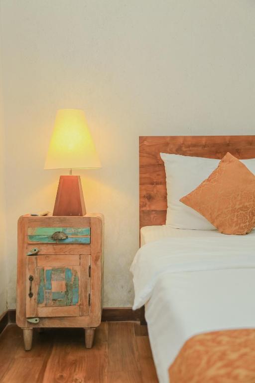 a bedroom with two beds and a night stand with a lamp at Grace in Nuwara Eliya