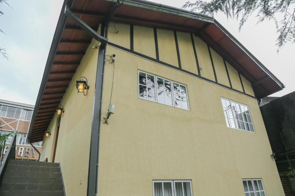 a yellow house with two windows on the side of it at Grace in Nuwara Eliya