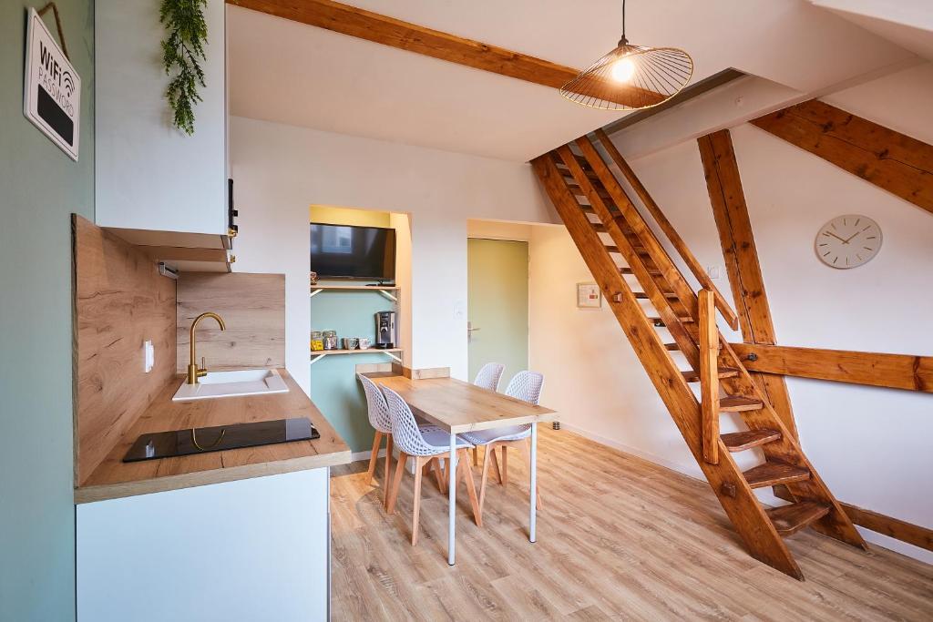 een keuken en eetkamer met een houten tafel bij Le duplex contemporain in Pontarlier