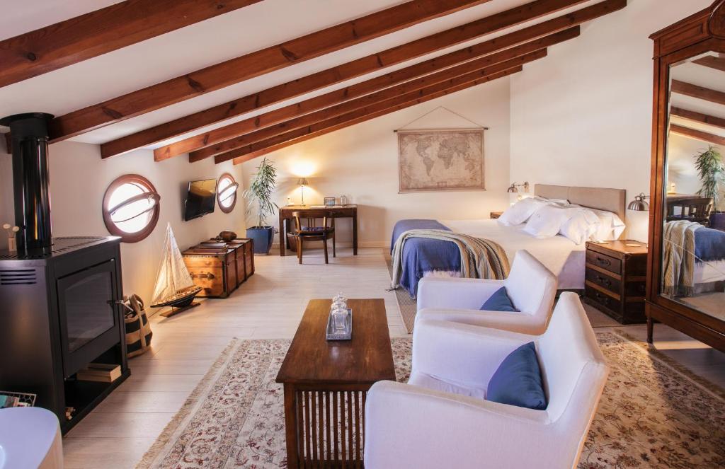 een slaapkamer met een bed en een woonkamer bij Jardí de Ses Bruixes Boutique Hotel in Mahón