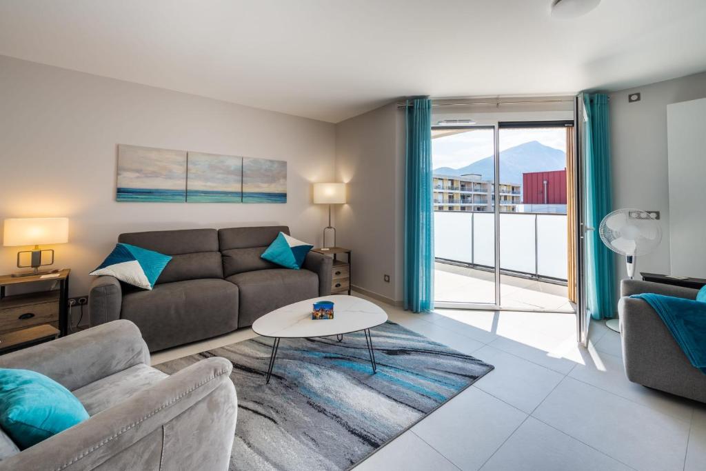ein Wohnzimmer mit einem Sofa und einem Tisch in der Unterkunft Le luminance - Appartement d'exception dans un quartier calme in Annecy