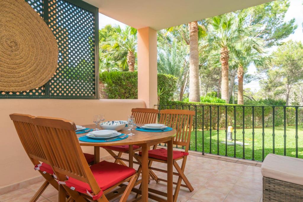 una sala da pranzo con tavolo e sedie e un balcone di Barca Trencada -A3- a Cala Mondrago