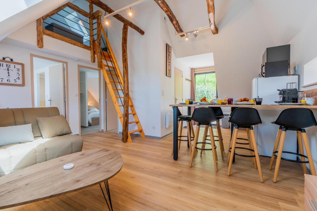 uma cozinha e sala de estar com um sofá e uma mesa em Le Point Sublime - Netflix/Wifi Fibre/Terrasse em Banassac