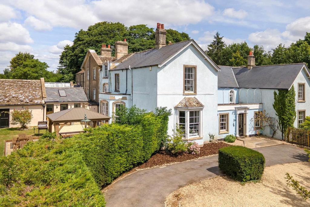 a large white house with a yard at Historic country house retreat with hot tub, ideal for large groups in Petty France