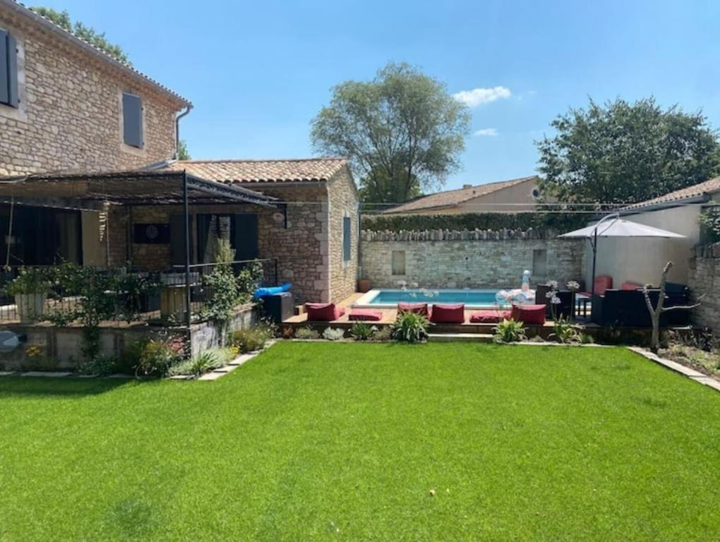 une cour avec une piscine et une maison dans l'établissement Lou Luberon, à Ménerbes