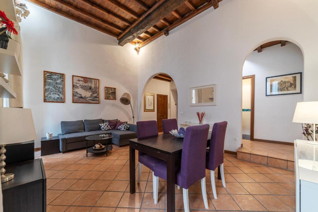 un soggiorno con tavolo e sedie viola di Pantheon Charming Apartment a Roma