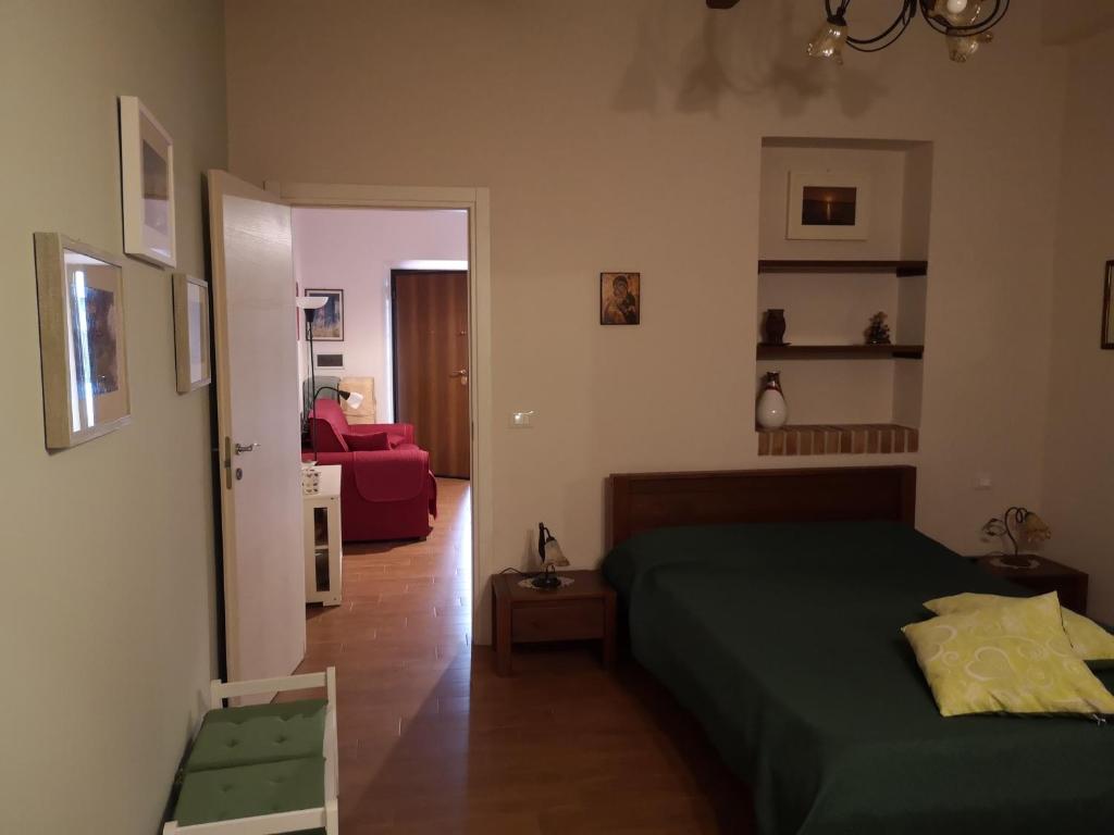 een slaapkamer met een groen bed en een rode bank bij Casa Indipendente in Villa San Giovanni