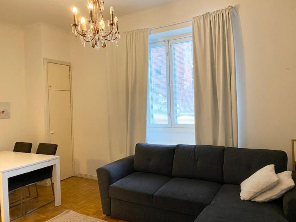 a living room with a couch and a table and a window at VALLILA - Helsinki sleeping beauty, 2 big rooms in Helsinki