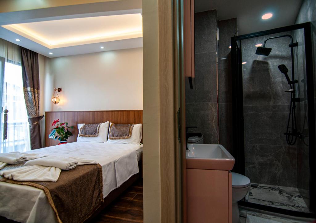 a bedroom with a bed and a bathroom with a sink at historia hotel in Istanbul