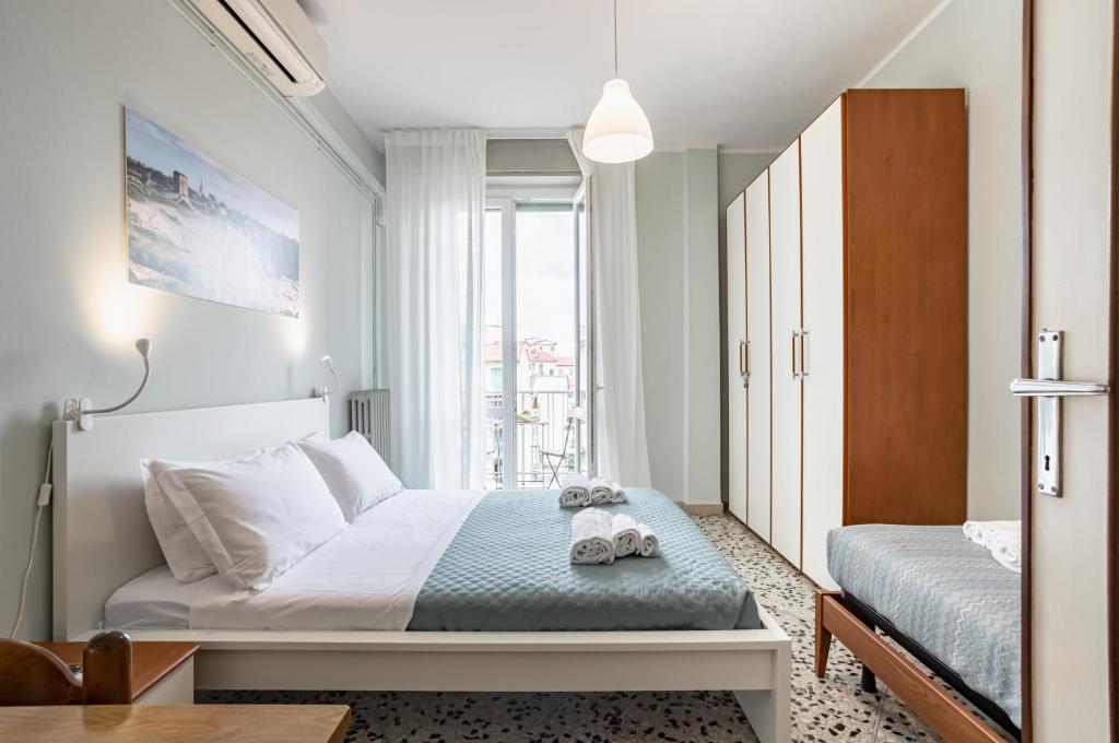 Habitación pequeña con cama y ventana en Yellowsunny Apartment with Two Balconies, en Pisa