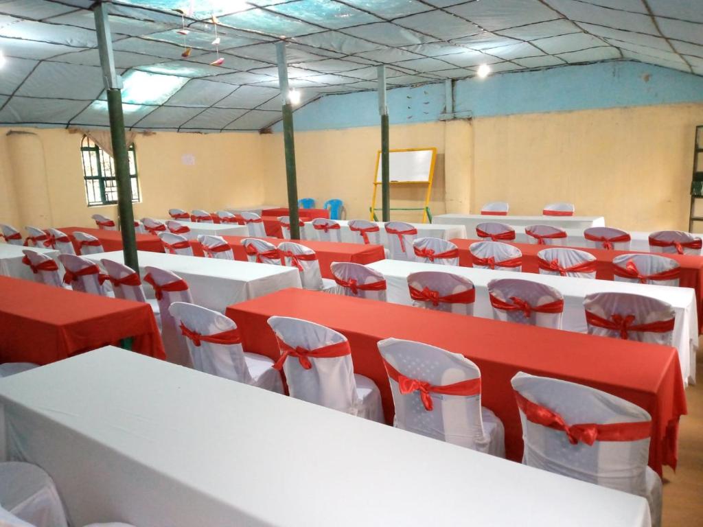 Zimmer mit roten und weißen Tischen und Stühlen in der Unterkunft SOFA CAMP NAIVASHA in Naivasha