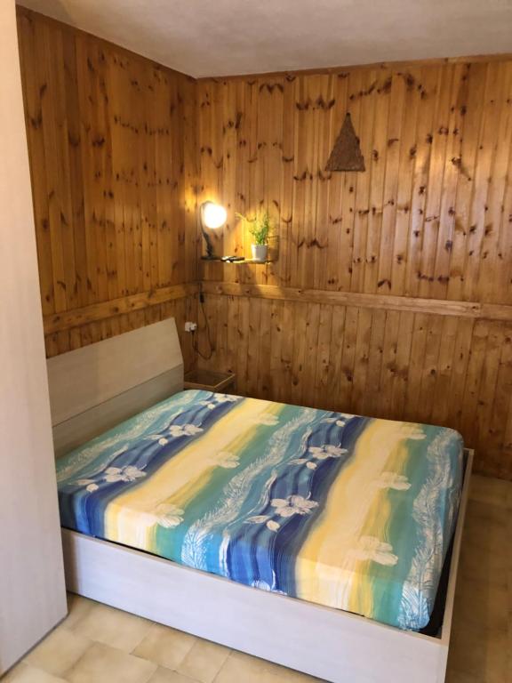 a bedroom with a bed with a wooden wall at Soggiorno rilassante in montagna in Riolunato