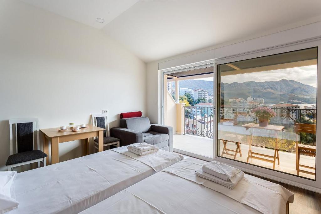 a bedroom with a large white bed and a large window at Apartments Gloria in Budva