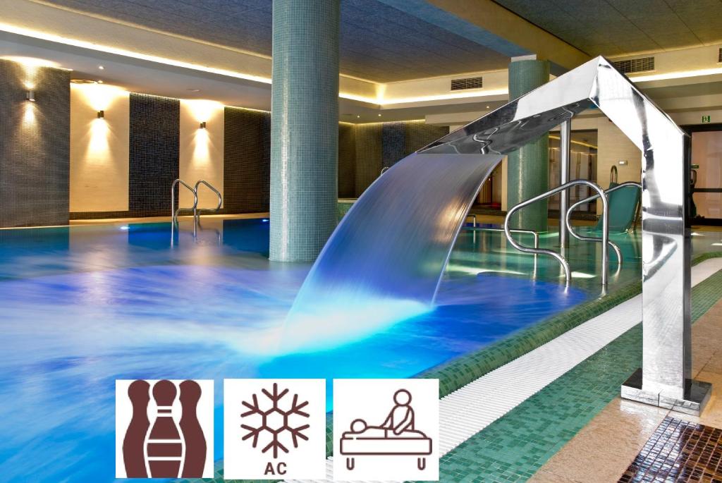- une piscine intérieure avec toboggan dans un bâtiment dans l'établissement Hotel Młyn Aqua Spa Biblioteka, à Elbląg