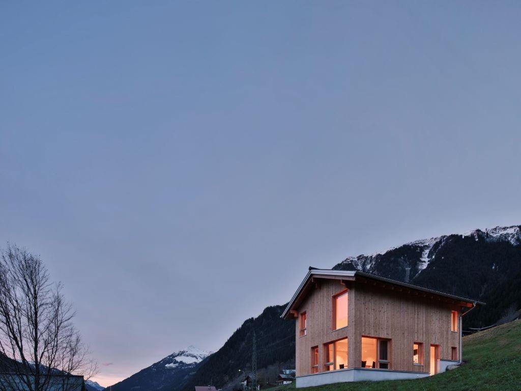 a house on a hill with mountains in the background at Haus Motta in Gaschurn