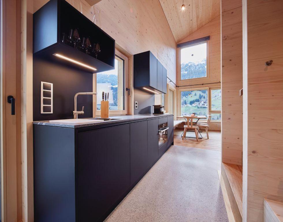a kitchen with black cabinets and a counter top at Haus Motta in Gaschurn