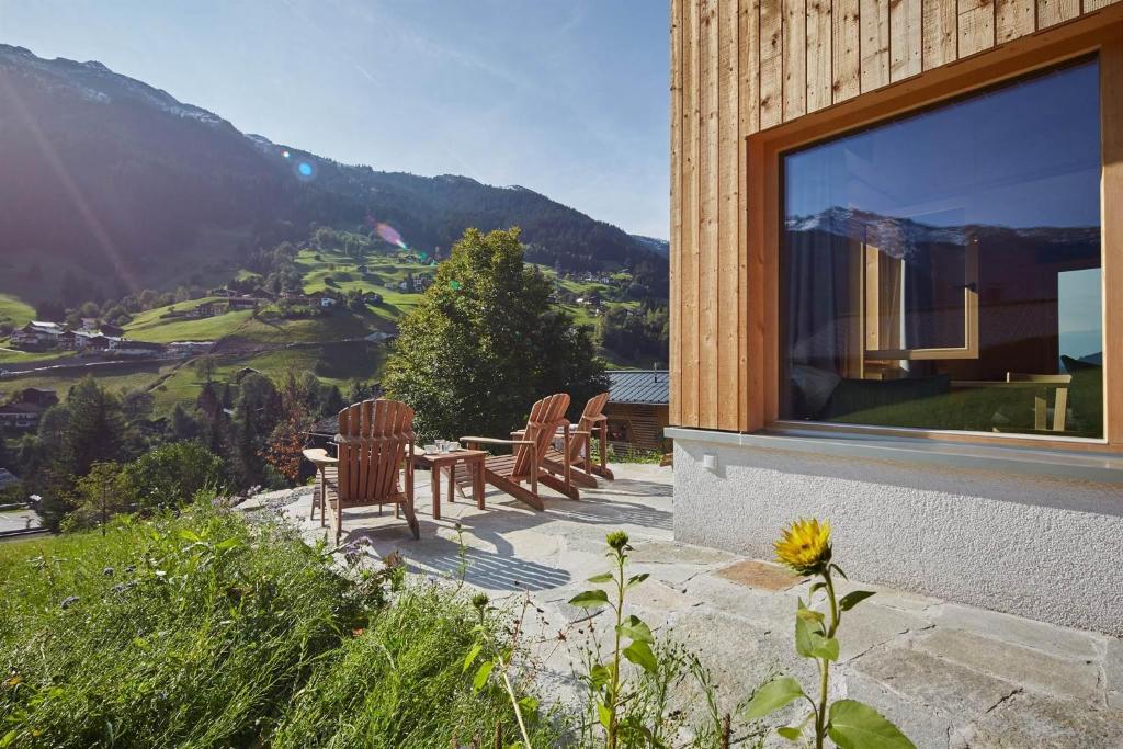 a patio with chairs and a table with a view of a mountain at Haus Motta in Gaschurn