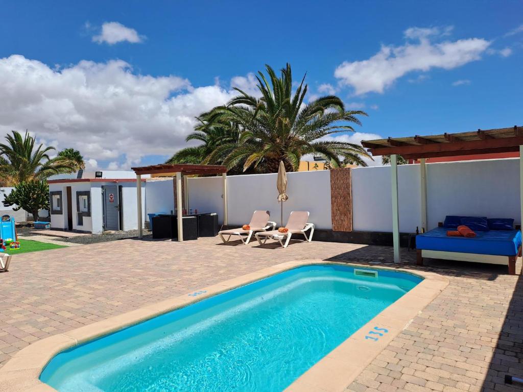 - une piscine dans une cour avec une maison dans l'établissement Villa Experience Heated Salty Water Pool, à Caleta de Fuste