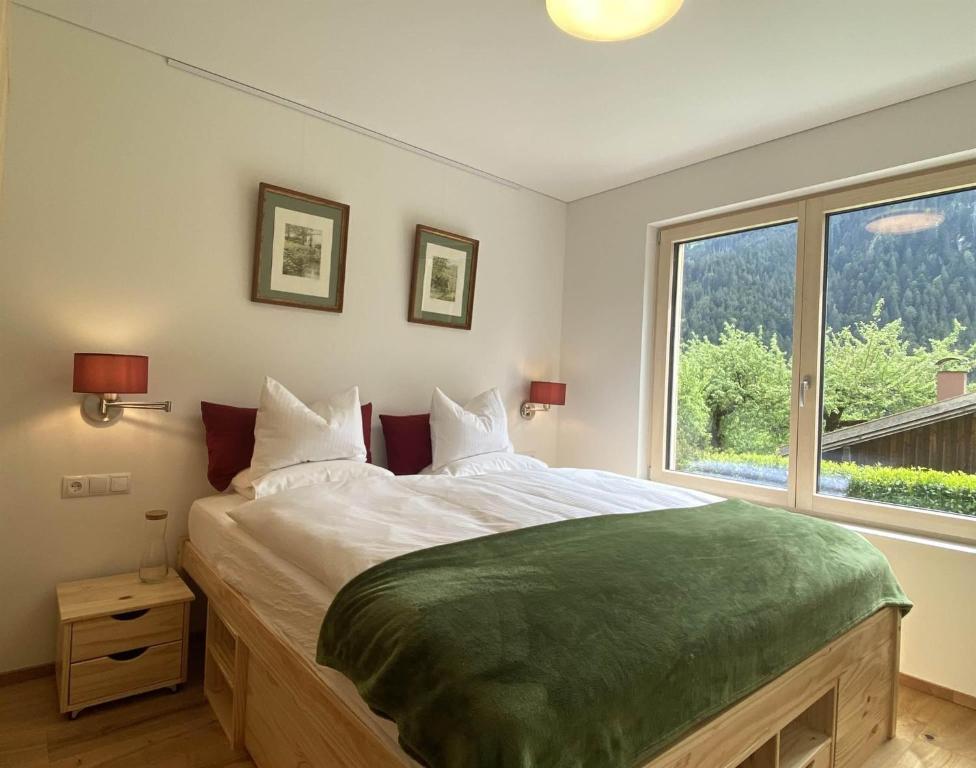 a bedroom with a large bed with a large window at Haus Albuin in Sankt Gallenkirch