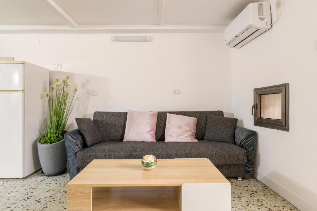 a living room with a couch and a table at ROMSUITES - Budget apartment at Center city, German colony Bahai gardens in Haifa