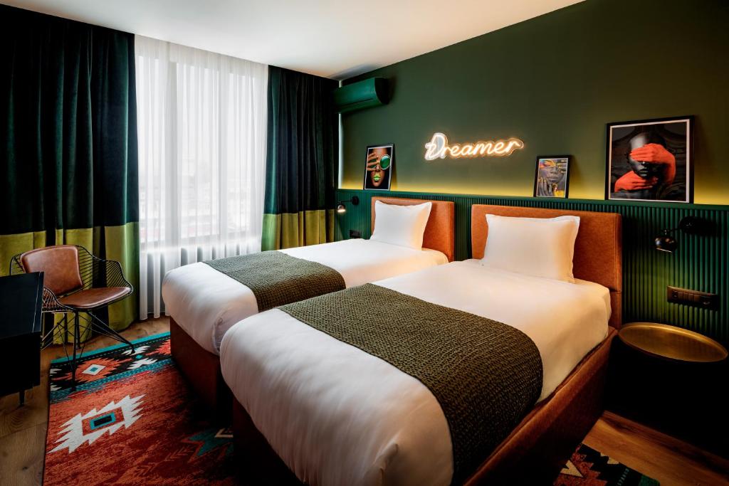 ソフィアにあるリラ ホテル ソフィアのベッド2台が備わる客室で、壁に看板が付いています。