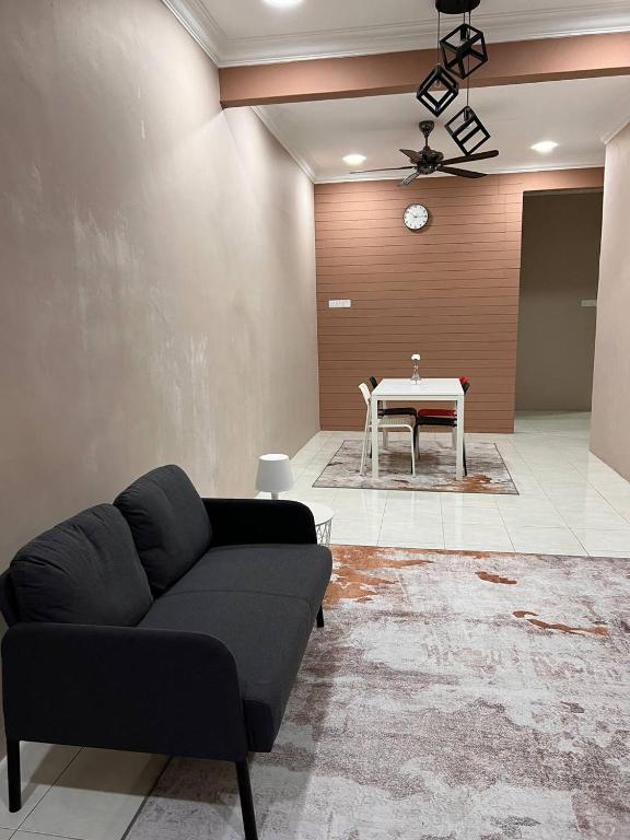 - un salon avec un canapé et une table dans l'établissement Rumah 127 - Homestay Taiping, à Simpang