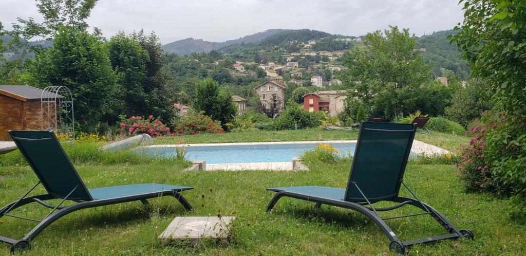 twee stoelen in het gras naast een zwembad bij MaDolceVia Chambres d'hôtes au coeur de Lamastre in Lamastre