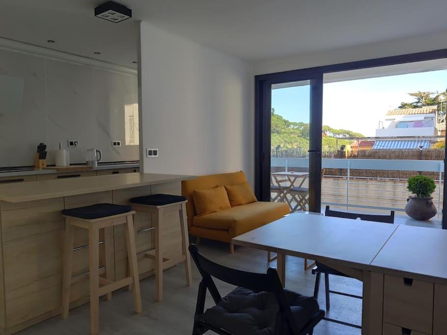 a kitchen and living room with a couch and a table at CHARMING APARTMENT IN CALDETES in Caldes d'Estrac