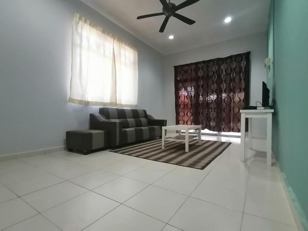 a living room with a couch and a table at Promenade Homestay 2 in Kampong Sura Masjid