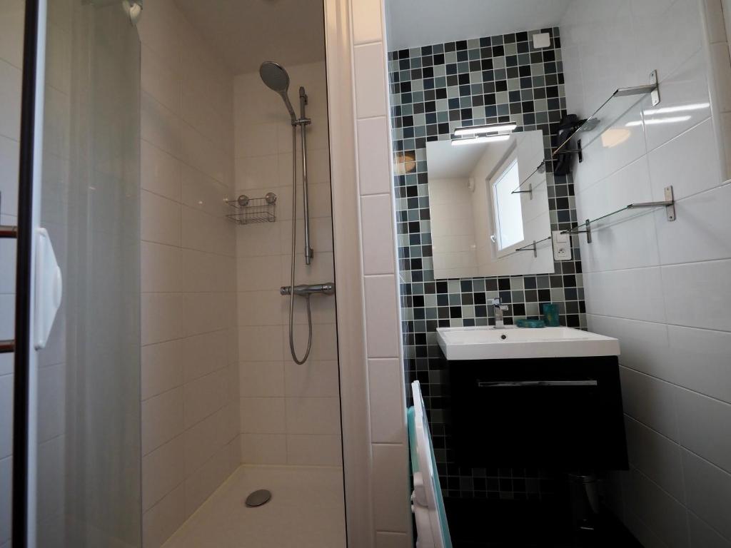 a bathroom with a sink and a shower with a mirror at 30 m des Plages - Port du Magouër - 6 invités in Plouhinec