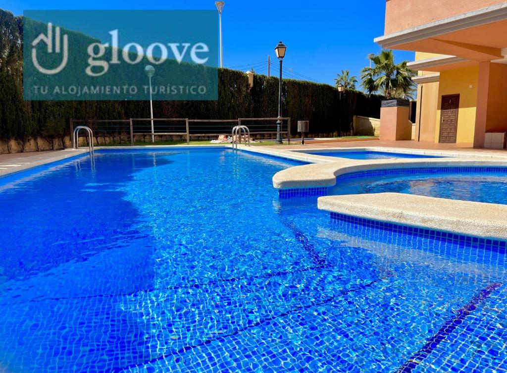una piscina con acqua blu di fronte a un edificio di Beach House by Gloove a Torrevieja