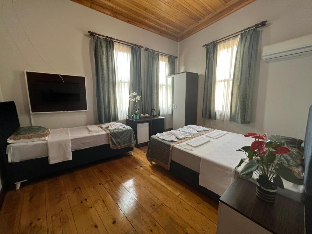 um quarto de hotel com duas camas e uma televisão em Grand almira hotel em Istambul