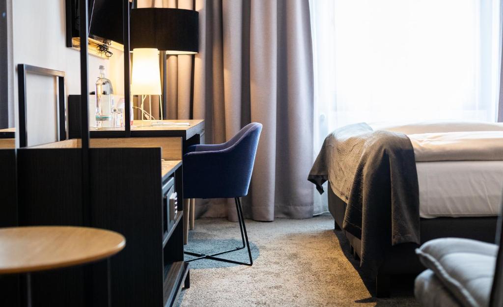 ハノーファーにあるYORS Boutique Hotelのベッド、デスク、椅子が備わるホテルルームです。