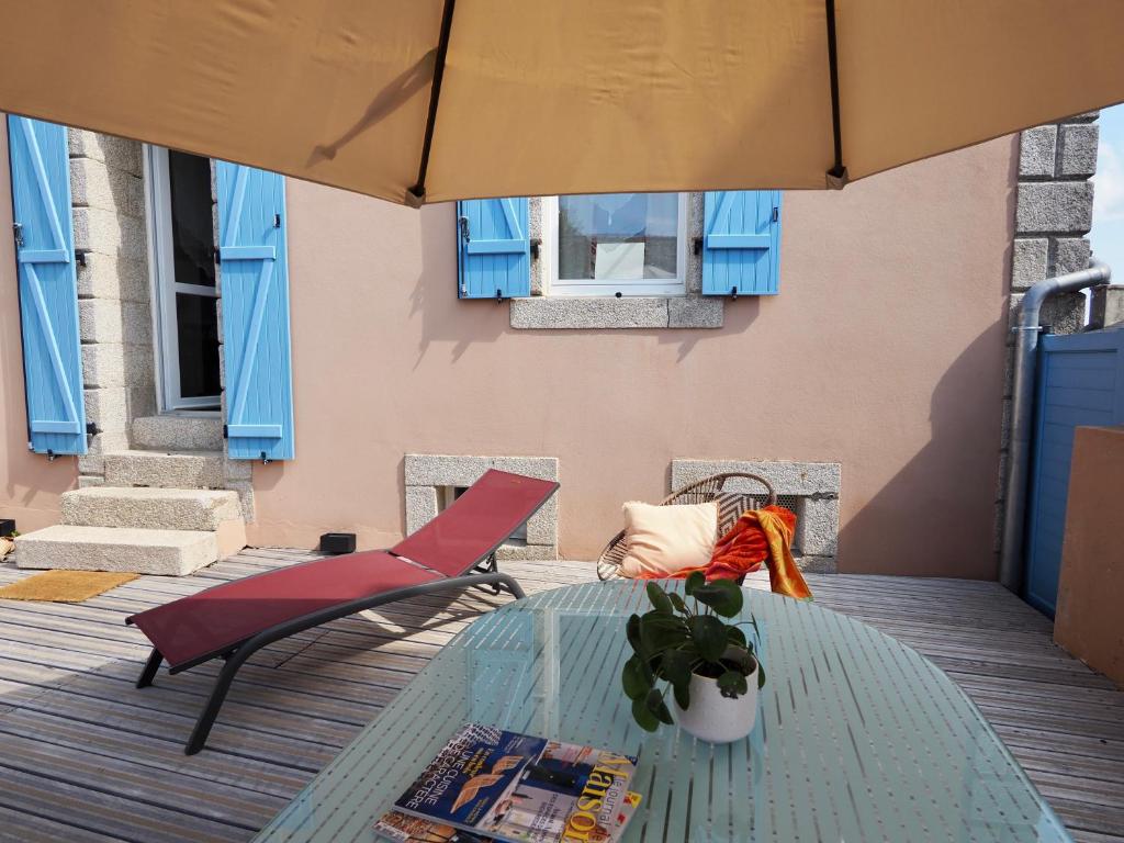 a glass table and chairs on a patio at 30 m des Plages - Port du Magouër - 6 invités in Plouhinec
