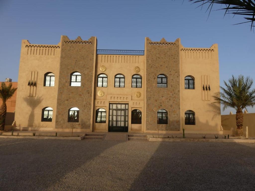 un grande edificio in mattoni con molte finestre di Riad La Luna a Merzouga