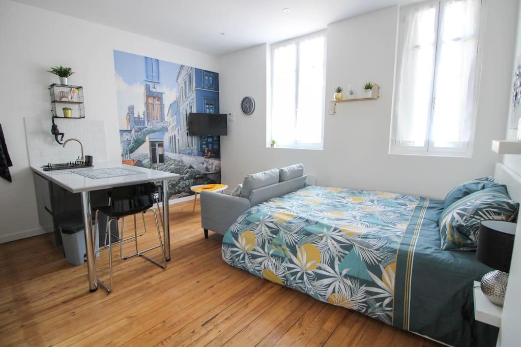 - un salon avec un lit et un bureau dans l'établissement Le Fanfrelin : Grand studio rénové/ Wi-fi, à Angoulême
