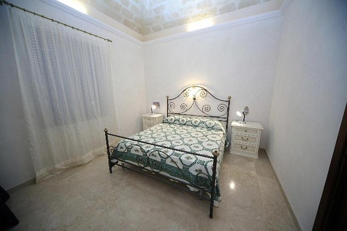 ein Schlafzimmer mit einem Bett und zwei Nachttischen in der Unterkunft Martufello in San Vito lo Capo