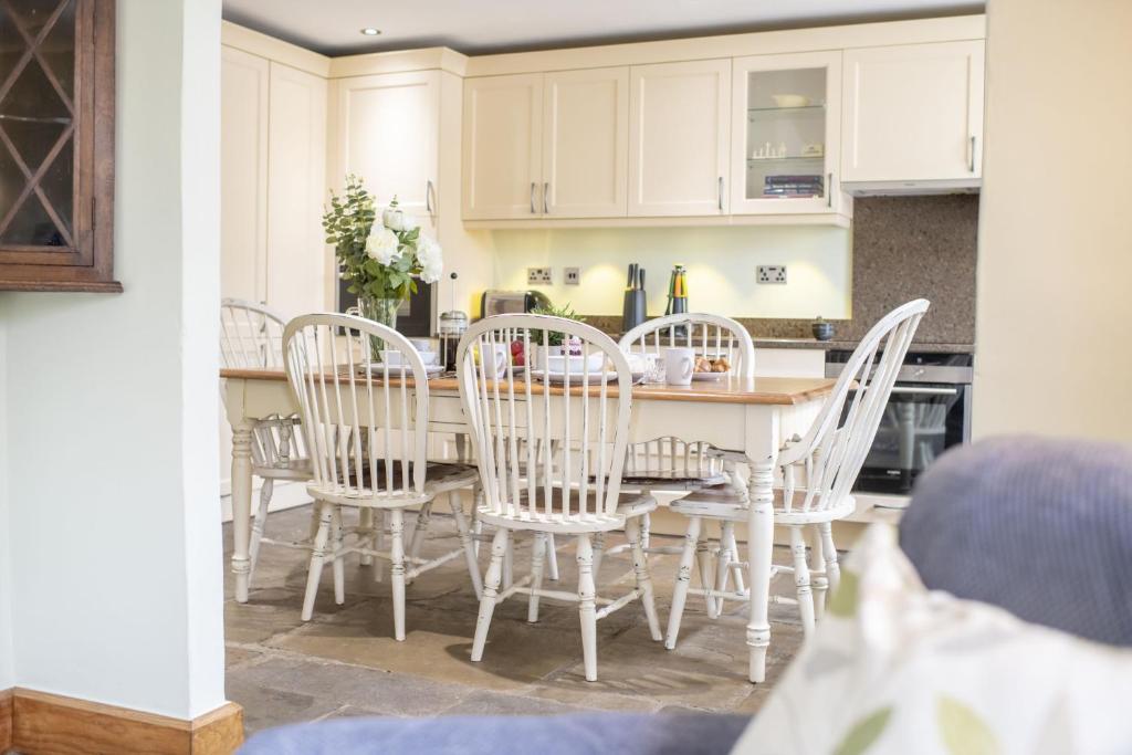 a kitchen with a dining room table and chairs at Aske House in Hawes