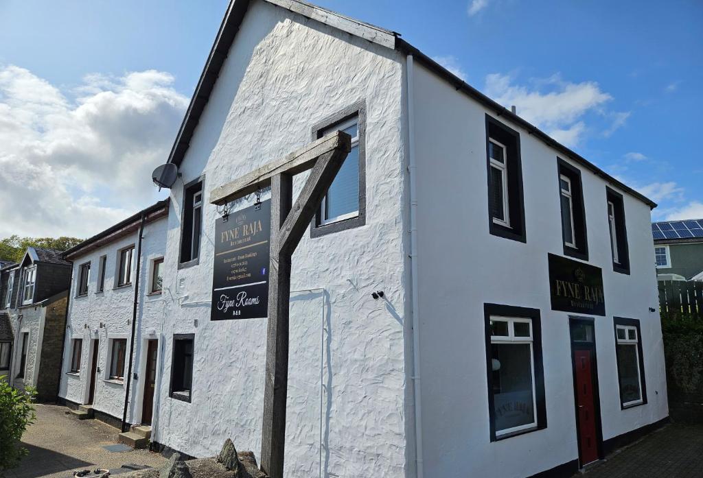 a white building with a sign on the side of it at Fyne Rooms in Tighnabruaich