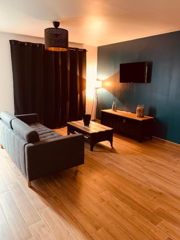 un salon avec un canapé et une télévision à écran plat dans l'établissement Villa Alba, à Auménancourt-le-Petit