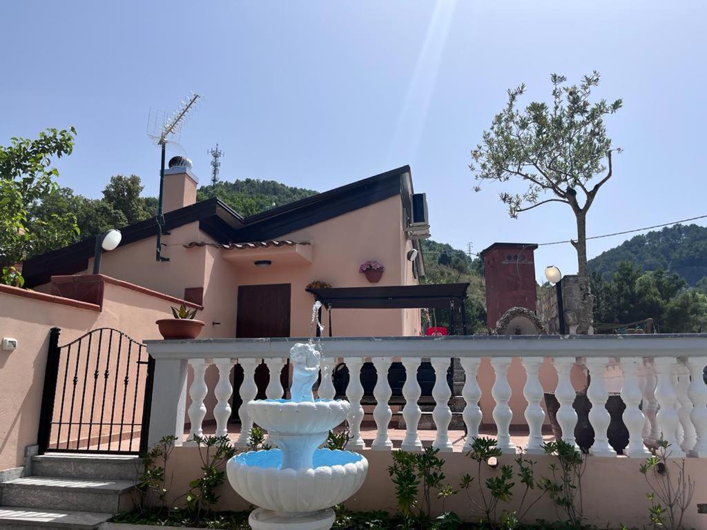 a white fountain in front of a house at B&B antonio in Aieta