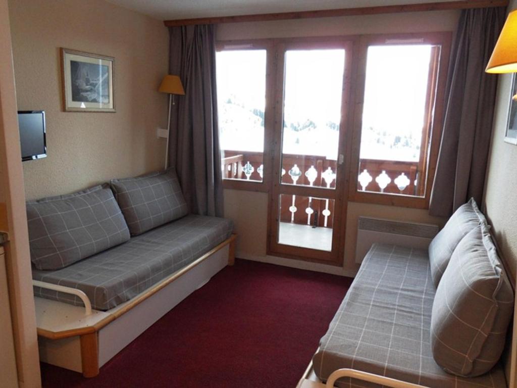 une chambre d'hôtel avec un canapé et une fenêtre dans l'établissement Appartement 5 pers, accès pistes, animaux admis - FR-1-181-2153, à La Plagne Tarentaise