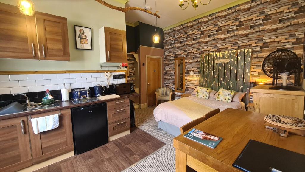 une cuisine et une chambre avec un lit dans une pièce dans l'établissement The Alder Studio @ The Pheasant, à Telford