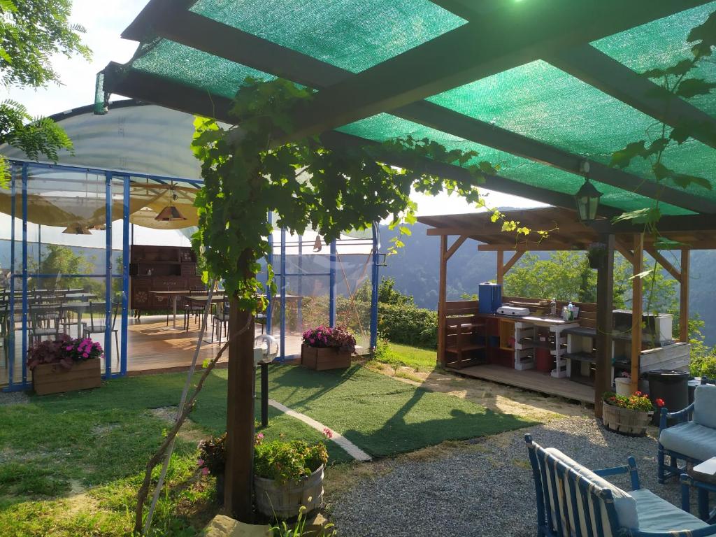 a garden with a pergola and a table and chairs at Yurte in Langa in Bosia