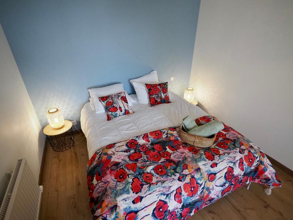 a bedroom with a bed with a floral bedspread at 30 m des Plages - Port du Magouër - 6 invités in Plouhinec