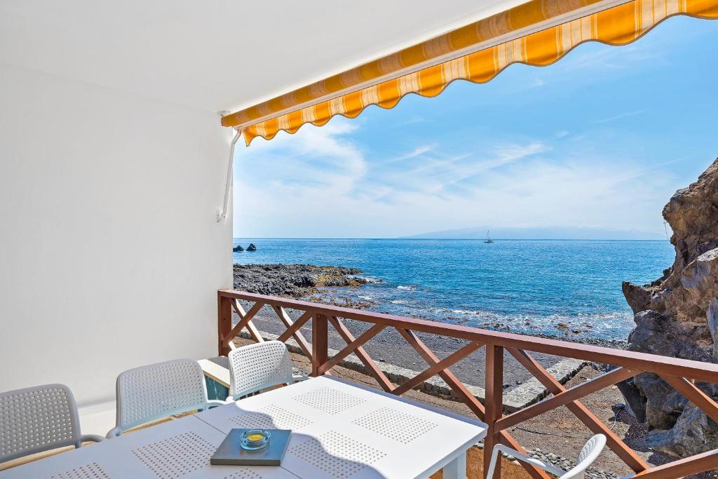 Un balcón con mesa y sillas y el mar. en Duplex Ocean View Apartment in Neptuno, en Puerto de Santiago