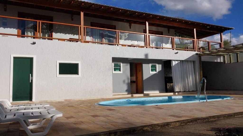 a house with a swimming pool in front of it at Pousada Sítio Vale das Olivas in Aiuruoca