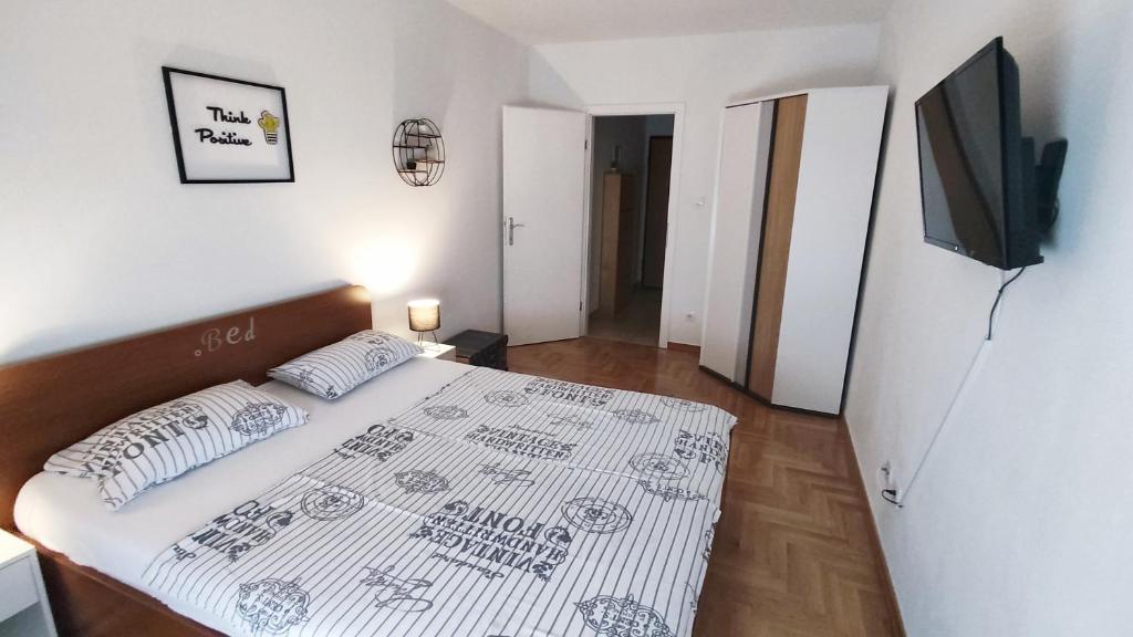 a small bedroom with a bed and a television at Apartment Angelus in Zagreb