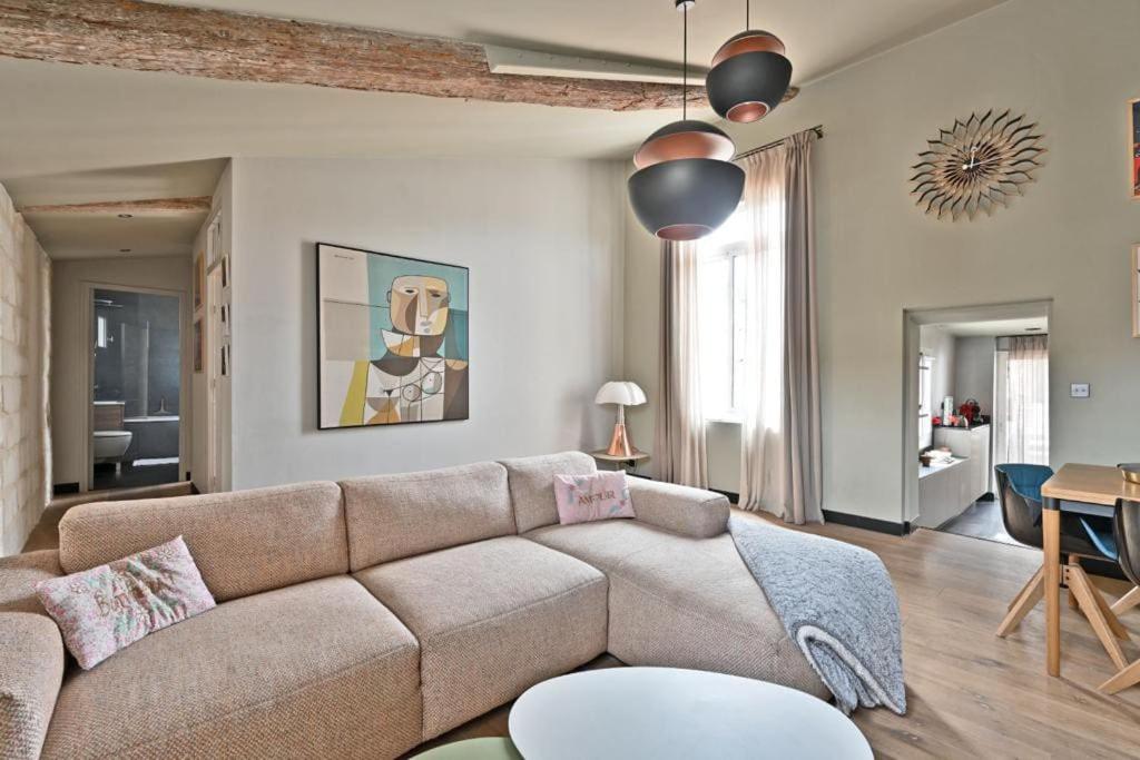 a living room with a couch and a table at Le Saint-Laurent - Parking Gratuit - Terrasse - Wi-Fi in Avignon