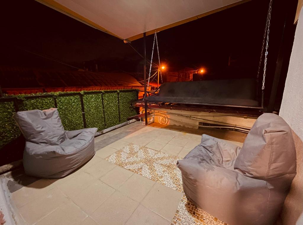 two chairs and a couch on a balcony at night at View Corner in Tbilisi City